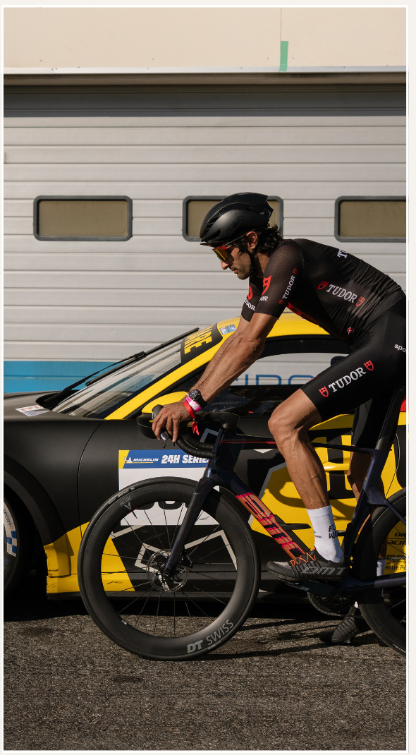 Antoine Leclerc à vélo devant la Porsche TUDOR — photo du dossier partenaires Sunset Bike